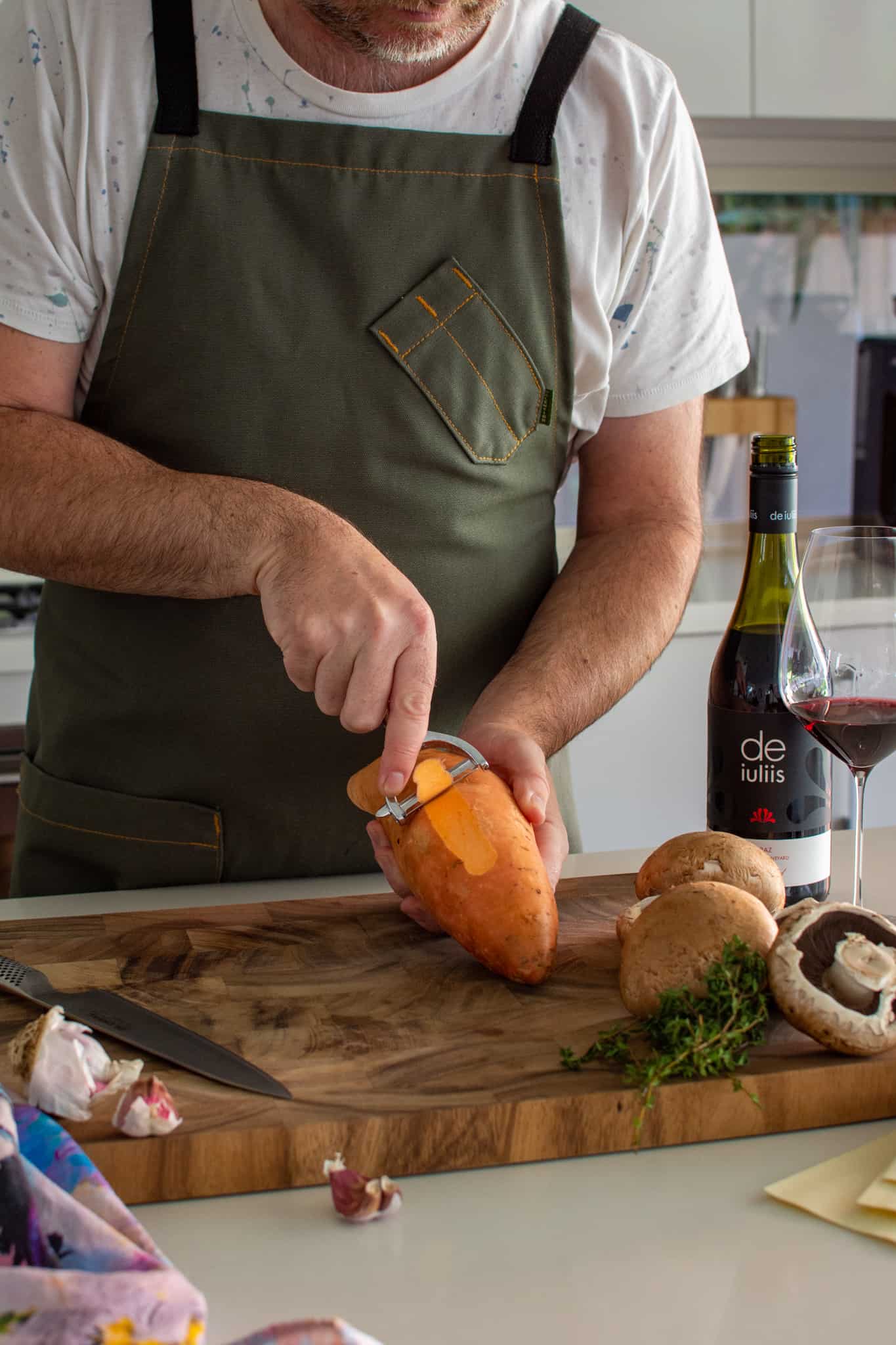 Somebody peeling a sweet potato in the kitchen