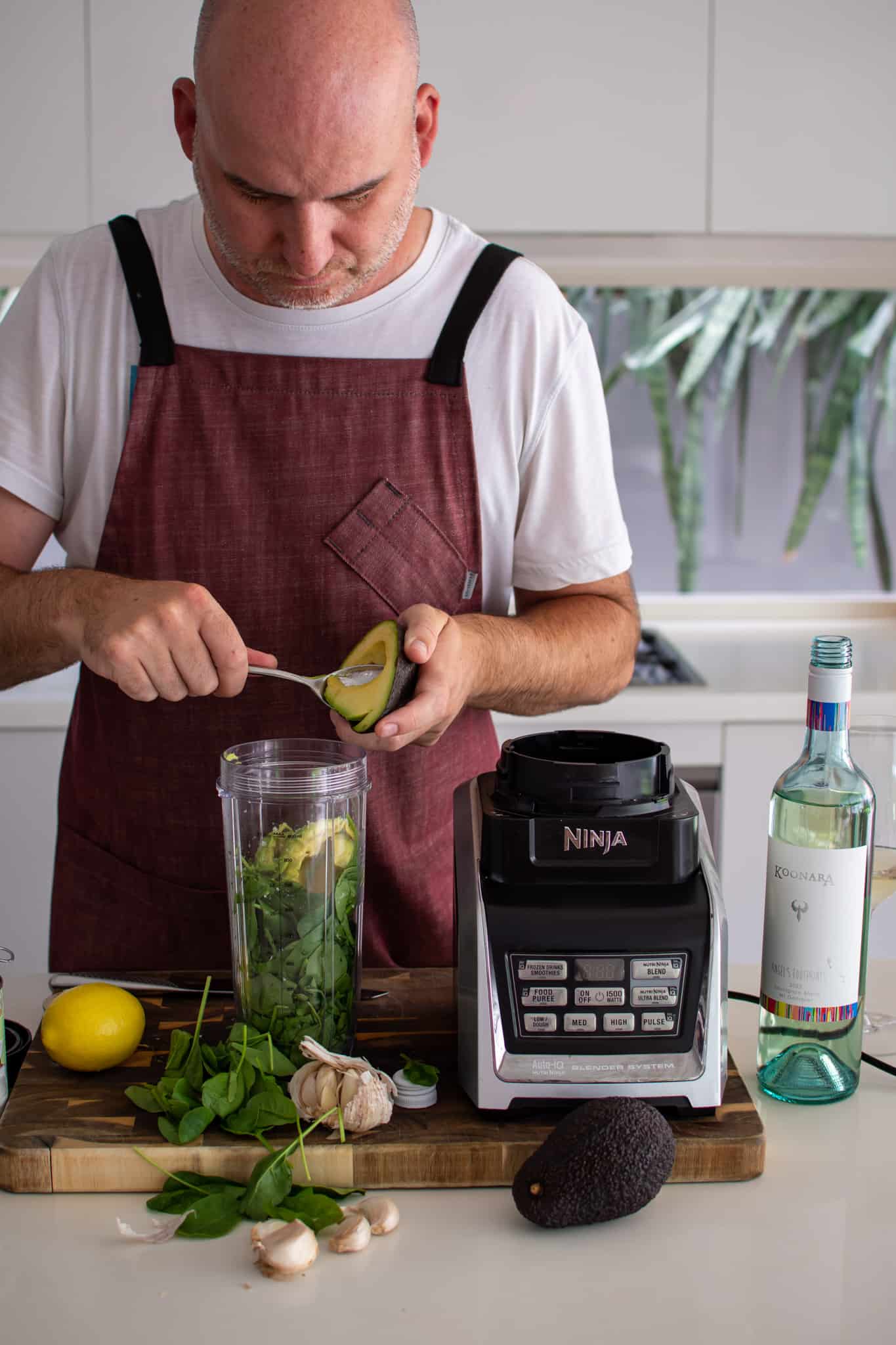 someone in the kitchen making sauce for avocado pasta