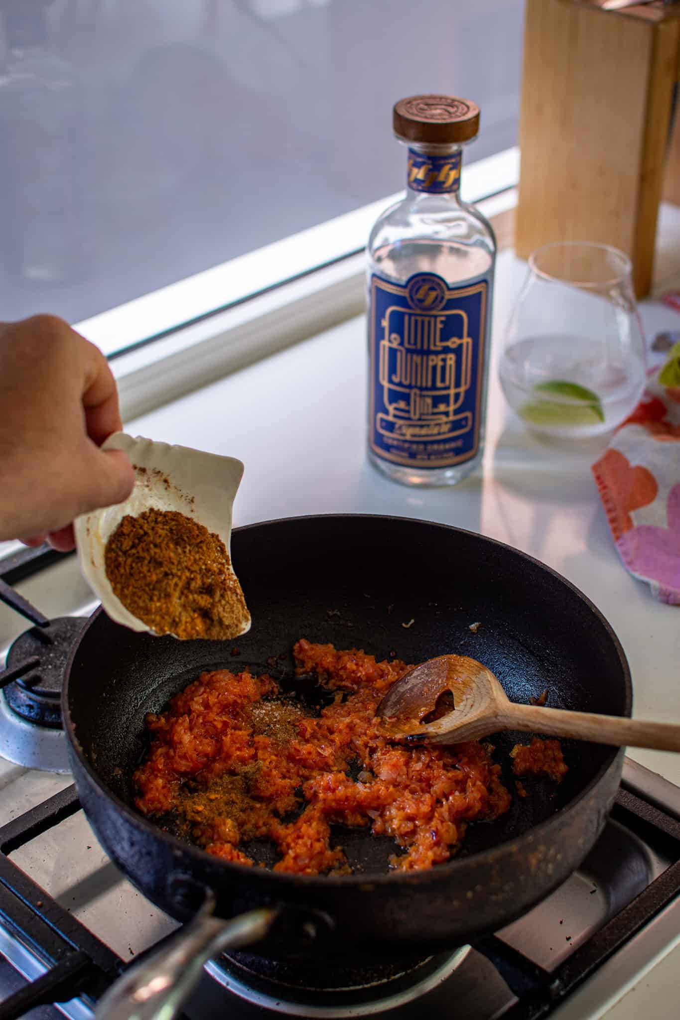 pouring curry spices into the saucepan