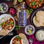 Birdseye view of swordfish curry and a bottle of gin